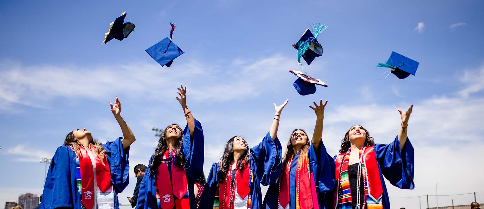 MSU Denver graduates throwing their caps in the air.